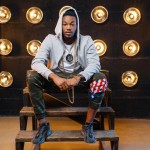 Black rapper in hoodie sitting on the steps