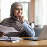 Successfull muslim woman manager working while sitting at cafe
