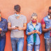 People using apps too much, Picture of young people on a walls looking at their smartphone apps.