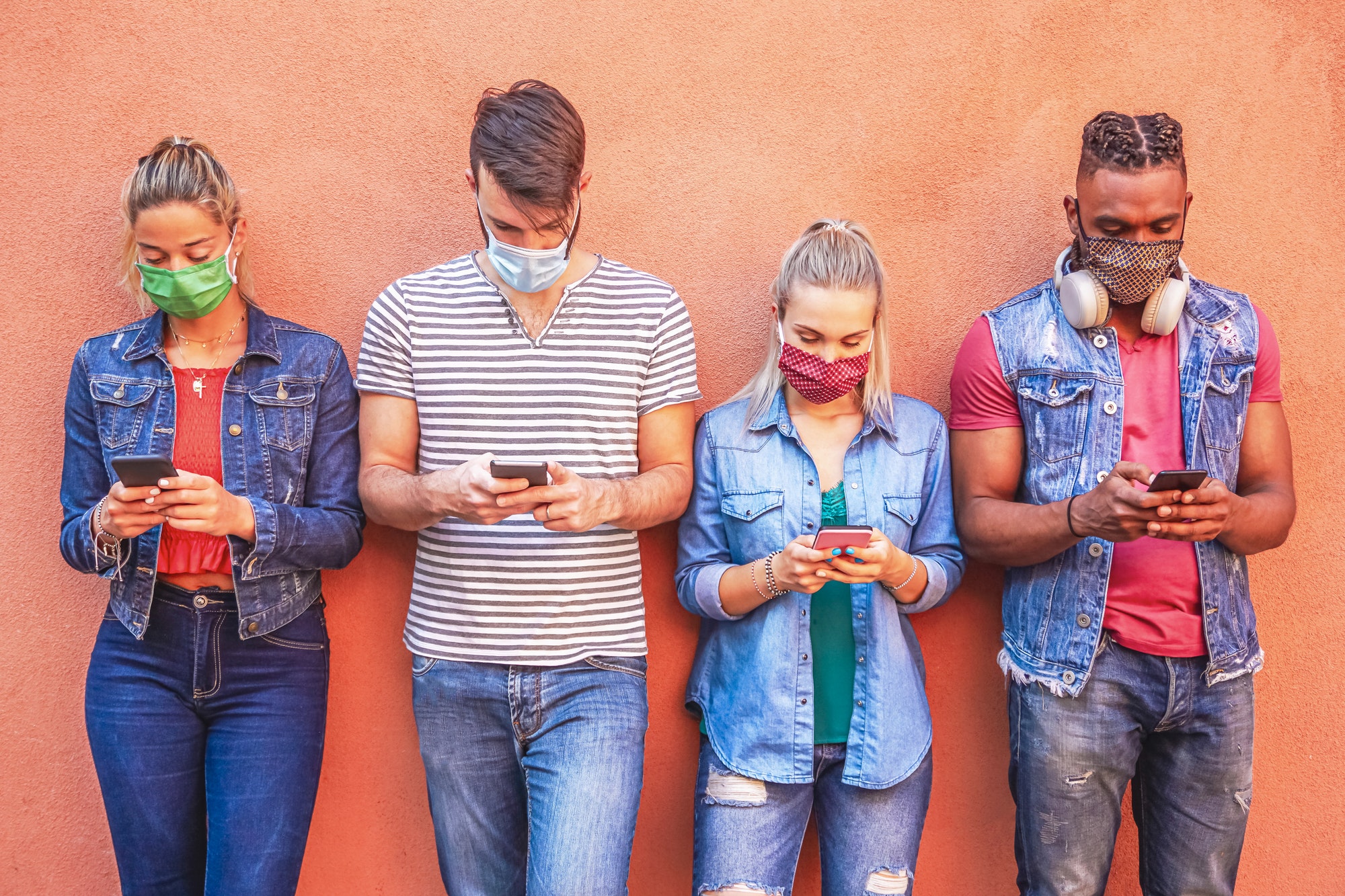 People using apps too much, Picture of young people on a walls looking at their smartphone apps.